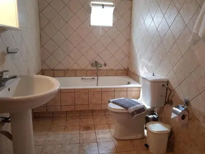 a bathroom with a tub and a toilet and a sink at Eftihia's Traditional House in Loúlos