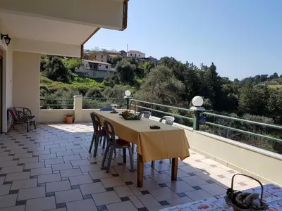 a table and chairs on a patio with a view at Eftihia's Traditional House in Loúlos