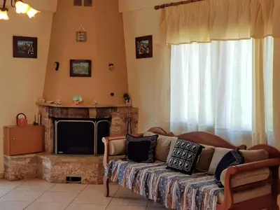 a living room with a couch and a fireplace at Eftihia's Traditional House in Loúlos