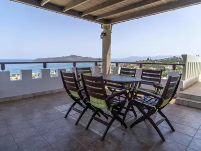 a table and chairs on a balcony with a view of the ocean at Modern holiday home in Stalos with balcony in Stalos