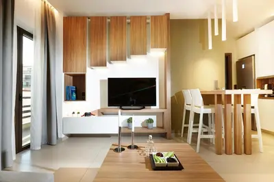 a living room with a television and a table with chairs at Armi Luxury Apartment in the Heart of the City in Chania Town