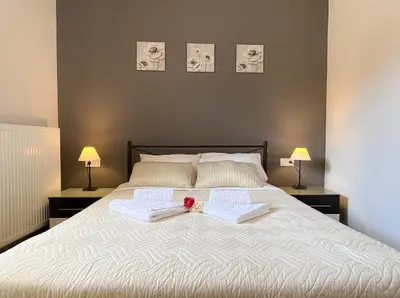 a bedroom with a bed with two towels and two lamps at Antigoni's Studio Cozy Private Apartment in Kissamos