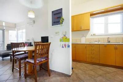 a kitchen and dining room with a table and a refrigerator at Sunny Apartment in Daratso