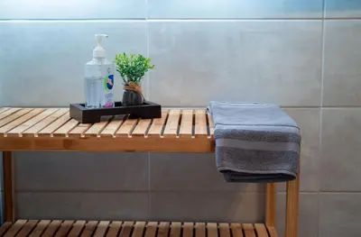 a wooden shelf with a bottle of soap and a towel at Mare I - studio in Old Harbor in Chania Town