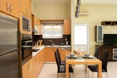 a kitchen with a wooden table and a kitchen with a dining room at Amaen Apartment in Chania Town