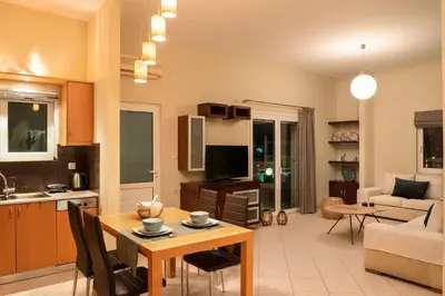 a kitchen and living room with a table and a couch at Amaen Apartment in Chania Town
