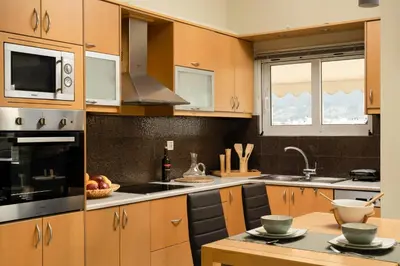 a kitchen with wooden cabinets and a counter top at Amaen Apartment in Chania Town