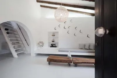 a white living room with a bench and a staircase at Monastery Estate Guesthouse in Sougia