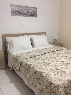 a bedroom with a large bed with a floral bedspread at Anatoli View in Agia Marina Nea Kydonias