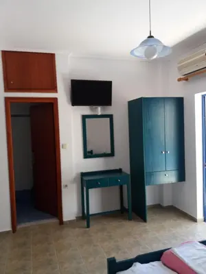 a bedroom with a blue cabinet and a table at Galini Studios in Palaiochóra