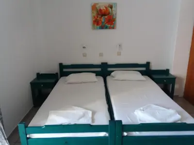 a bedroom with two beds and a picture on the wall at Galini Studios in Palaiochóra