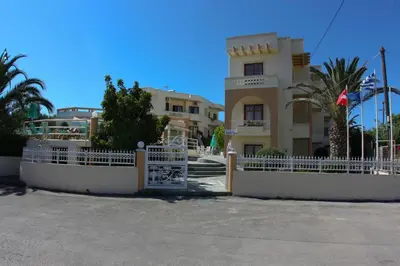 a white fence in front of a building at Olga Suites in Maleme