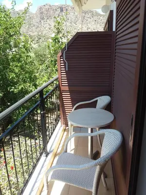 a table and two chairs on a balcony with a view at Oasis Studios in Palaiochóra