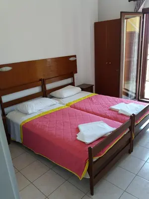 a bedroom with a large bed with a wooden headboard at Oasis Studios in Palaiochóra