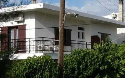 a white house with a balcony in front of it at Oasis Studios in Palaiochóra