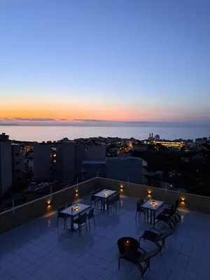a rooftop patio with tables and chairs at sunset at Casa di Halepa in Chania Town