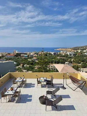 a patio with tables and chairs and an umbrella at Casa di Halepa in Chania Town