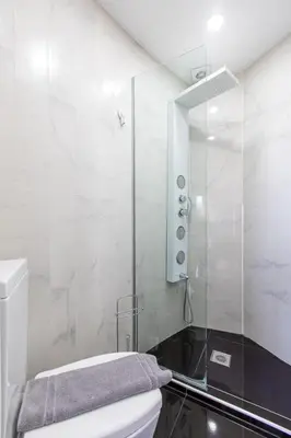 a bathroom with a toilet and a glass shower at Villa Dione Palace in Falasarna