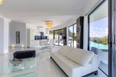 a living room with a white couch and a glass table at Villa Dione Palace in Falasarna
