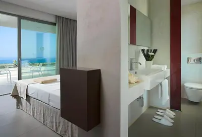 a hotel room with a bed and a bathroom with a view at Youphoria Sea View Villas in Kissamos