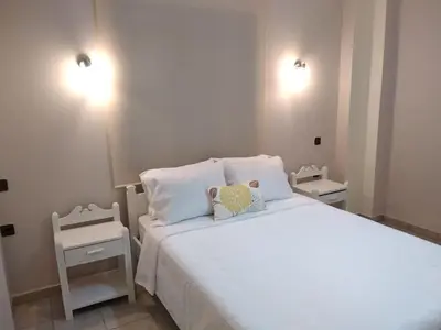 a bedroom with a white bed with two night stands at Elita Beachside in Chania Town