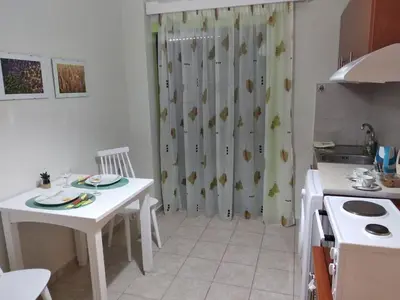 a kitchen with a table and a shower curtain at Elita Beachside in Chania Town