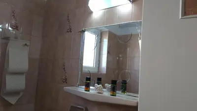 a bathroom with a shower with a mirror and a sink at Elita Beachside in Chania Town