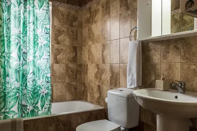 a bathroom with a toilet and a sink and a shower curtain at Thea Artemis in Kato Daratso