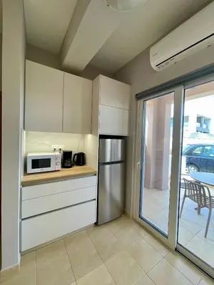 a kitchen with a refrigerator and a microwave at Thea Artemis in Kato Daratso