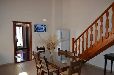 a dining room with a table and a staircase at Villa Eternity in Alikampos