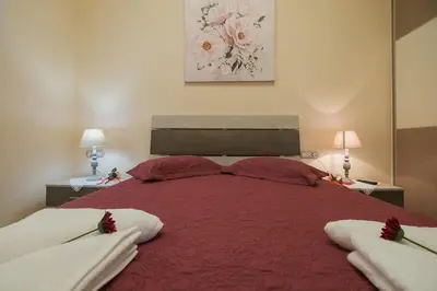 a large red bed in a bedroom with two lamps at Spacious Home with Parking in Chania Town