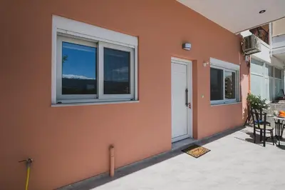 a orange wall with windows and a table and chairs at Spacious Home with Parking in Chania Town