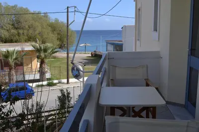 a balcony with a table and a view of the ocean at Adamas Rooms in Palaiochóra