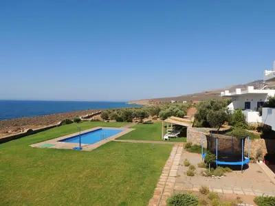 a villa with a swimming pool and the ocean at Studios Fokies in Khóra Sfakíon