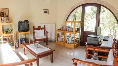 a living room filled with furniture and a tv at Crete holiday rental small village close to beaches -sharing a large pool in Vamos