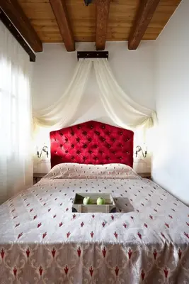 a large bed with a red headboard in a bedroom at Casa Perla Suites in Chania Town