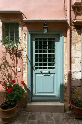 a blue door on a pink building with flowers at La Barchetta Old Town Home with Seaview in Chania Town