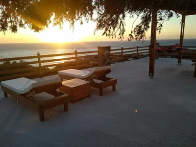 a group of benches sitting next to the ocean at Elafonisi House in Livadia