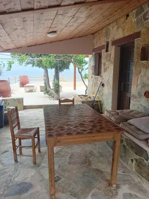 a wooden table and a chair in a room at Elafonisi House in Livadia