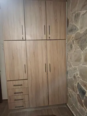 a row of wooden cabinets in a room with a stone wall at Elafonisi House in Livadia