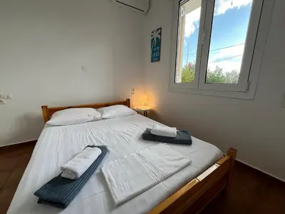 a bedroom with a bed with towels and a window at Stay Salty - Two Different Houses in Marathi