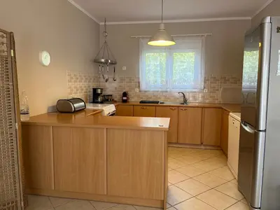 a kitchen with wooden cabinets and a refrigerator at Stay Salty - Two Different Houses in Marathi