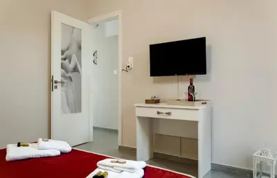 a living room with a television and a red rug at Sophia's Castle View Apartment in Chania Town