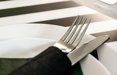 a fork and knife sitting on a white plate at Sophia's Castle View Apartment in Chania Town
