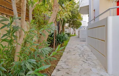 a walkway next to a building with plants at Saint Trope Studios in Kalamaki Chanion