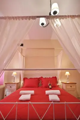 a bedroom with a red bed with red pillows at Sfakia Thea Apartments in Sfakiá