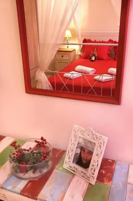 a bedroom with a mirror and a table with a picture at Sfakia Thea Apartments in Sfakiá