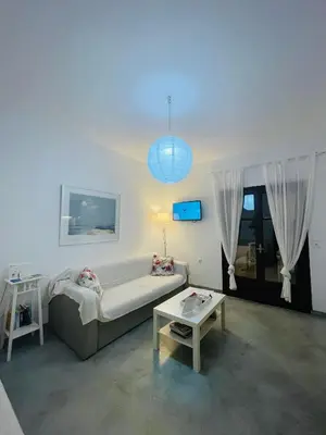 a living room with a couch and a table at Waves House in Kissamos