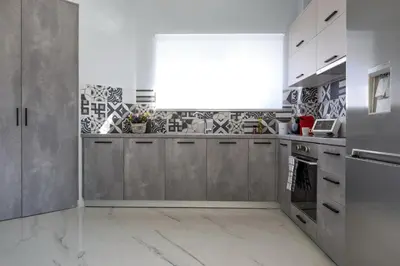 a kitchen with gray cabinets and a large window at E&G Relax Homes-E in Kissamos