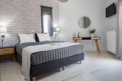 a bedroom with a large bed and a brick wall at E&G Relax Homes-E in Kissamos